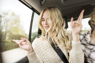 Portrait of young woman with eyes closed listening music in a car