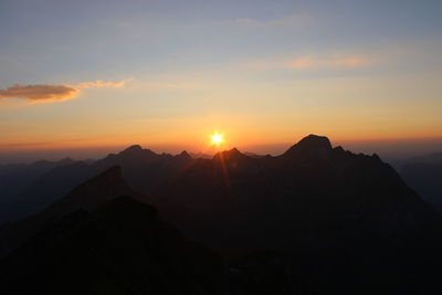 Scenic view of silhouette mountains against sky during sunset