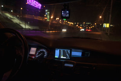 Cars on road seen through car windshield at night