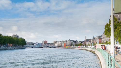 River amidst buildings in city against sky