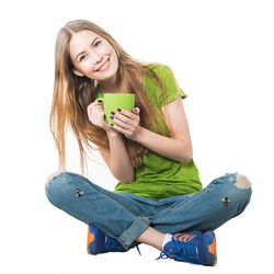 Portrait of smiling young woman holding mobile phone