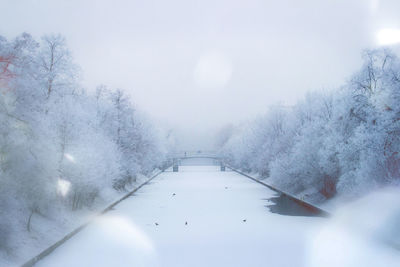 Close-up of wet road during winter against sky