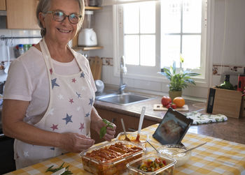 Portrait of woman preparing food at home