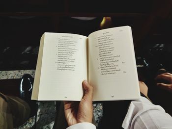 Midsection of person holding book