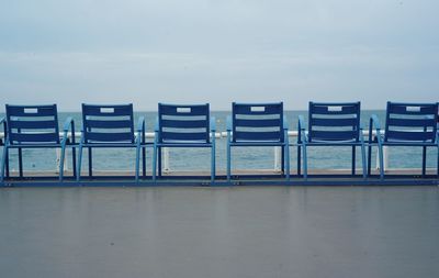 Chairs on beach against sky