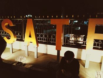 Rear view of man on illuminated restaurant at night