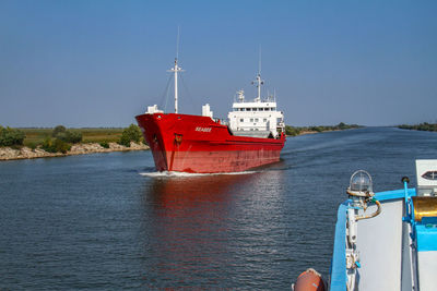 Boat sailing on sea against clear sky