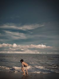 Full length of shirtless man on beach