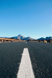 Road against clear blue sky