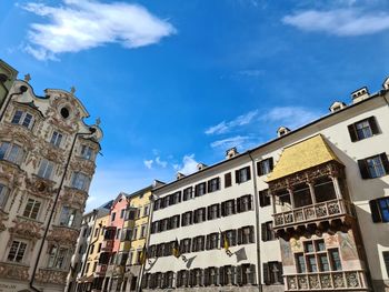 Low angle view of buildings against cloudy sky