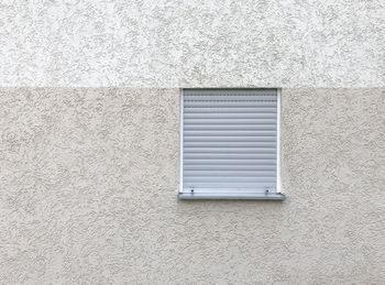 Low angle view of window on white wall