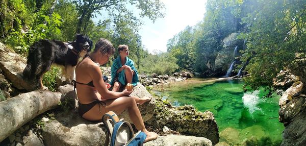 People sitting on rocks by plants