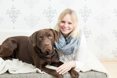 Portrait of smiling woman with dog at home