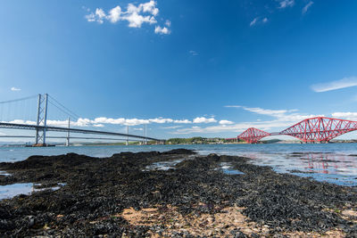 Bridge over sea shore against sky