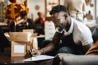 Male hairdresser writing on paper at barber shop