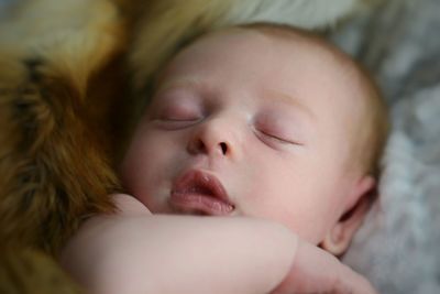 Close-up of newborn baby sleeping on fake fur