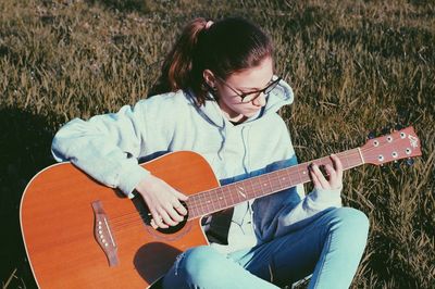 High angle view of woman playing guitar