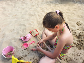 High angle view of girl playing with toy on beach