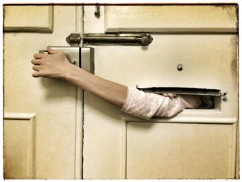 Man unlocking door through mail slot