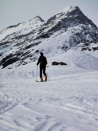 People on snowcapped mountain against sky