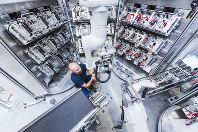 Man working at industrial robot in modern factory