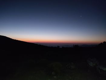 Scenic view of silhouette landscape against clear sky at sunset