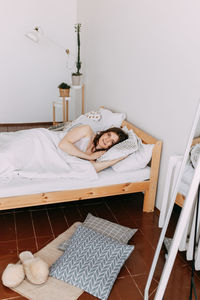 Portrait of woman lying on bed at home