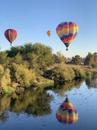 Hot air balloons flying over lake