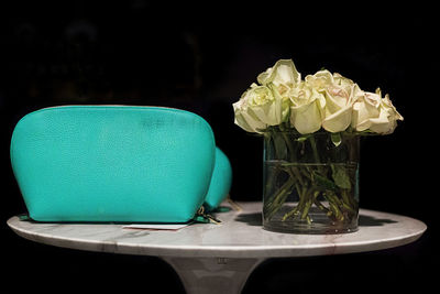 Close-up of flower vase on table against black background