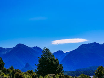 Scenic view of mountains against blue sky