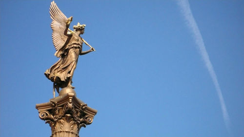 Low angle view of statue against blue sky