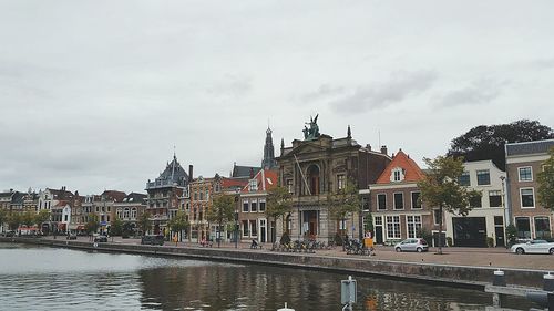 River amidst buildings in city against sky