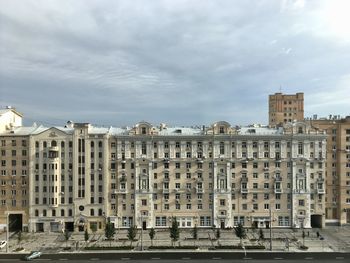 Buildings in city against cloudy sky