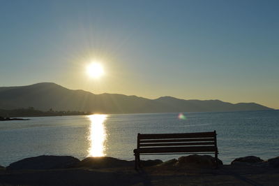 Empty bench overlooking calm lake