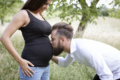 Side view of couple standing on field