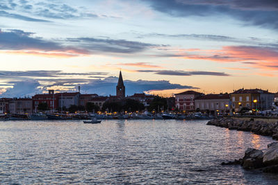 View of city at waterfront during sunset