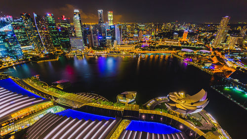 High angle view of illuminated buildings by river at night
