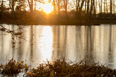 Scenic view of lake against sky at sunset