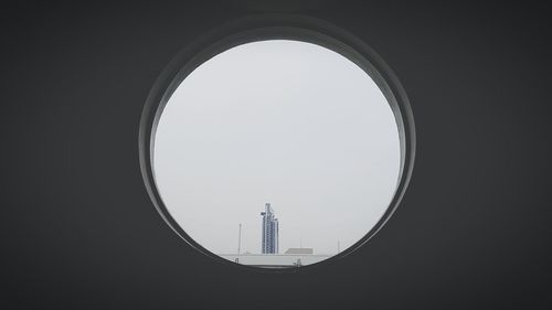 Buildings against clear sky seen through arch window