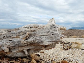 Rock formations on landscape against cloudy sky