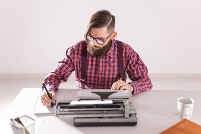 Mid adult man using smart phone on table