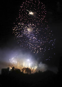 Low angle view of firework display at night