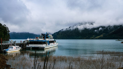 Fishing boat in lake against sky