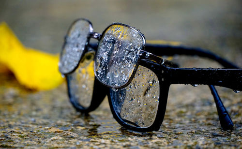 Raindrops on reading glasses placed on a concrete background