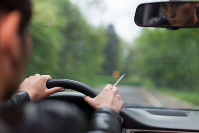 Close-up of woman driving car on road