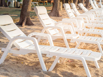 Empty chairs and table on field