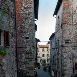 Narrow street amidst buildings against sky