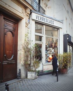 Reflection of woman in front of building