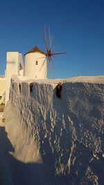 Traditional white windmill against clear sky during sunset