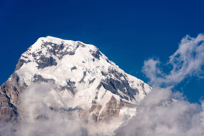 Scenic view of snowcapped mountains against blue sky